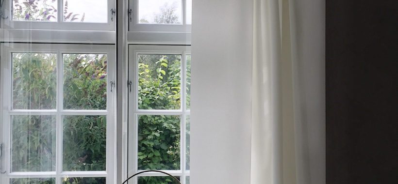 Billede af et vindue med sprossede vinduer og smukke hvide gardiner designet af Ronan & Erwan Bouroullec i kvadrat stof . I vindueskarmen ses den flotte Klong lysestage.