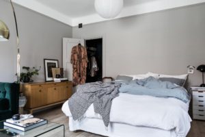 Her ses et soveværelse placeret i stuen. Sengen står op af en lys kølig går væg.