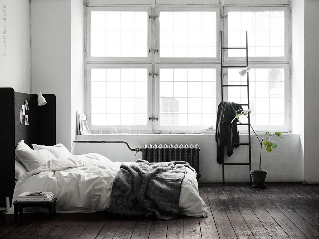 Råt soveværelse med højt hovegærde lavet ud af afskærmingssvæg fra Ikea