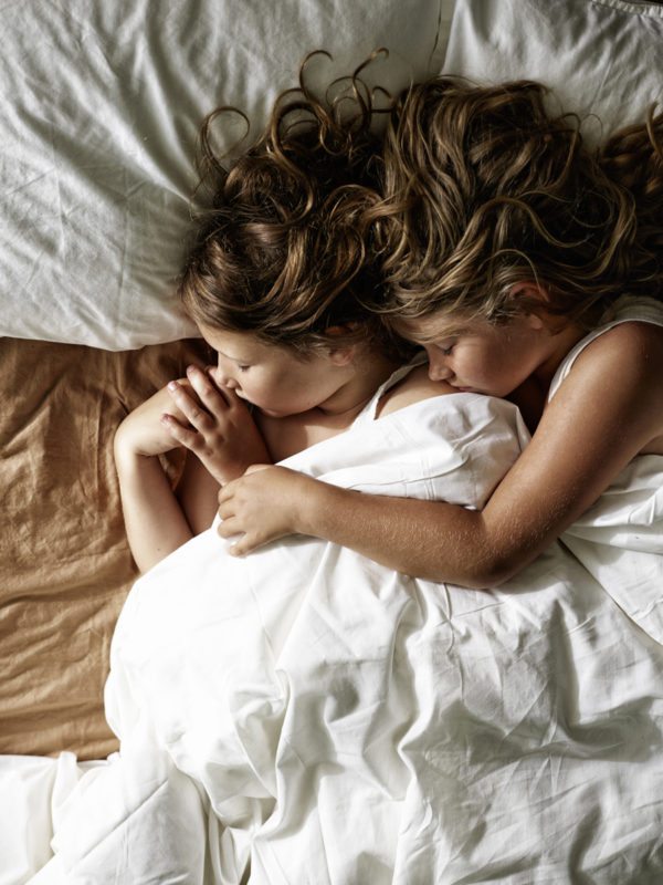 To små børn der sover arm i arm