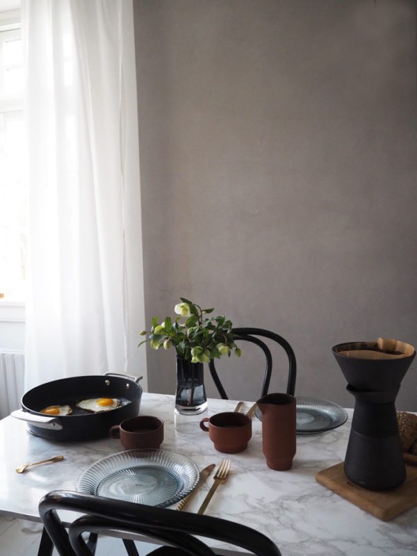 Morgenbord med spejlæg og kaffe og blomster i smuk vase på bordet