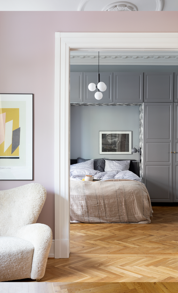Kig fra stue ind i et soveværelse med grå vægge og indbyggede skabe. Hjemme hos boligstylist Malene Marie Møller fra Bolgicious